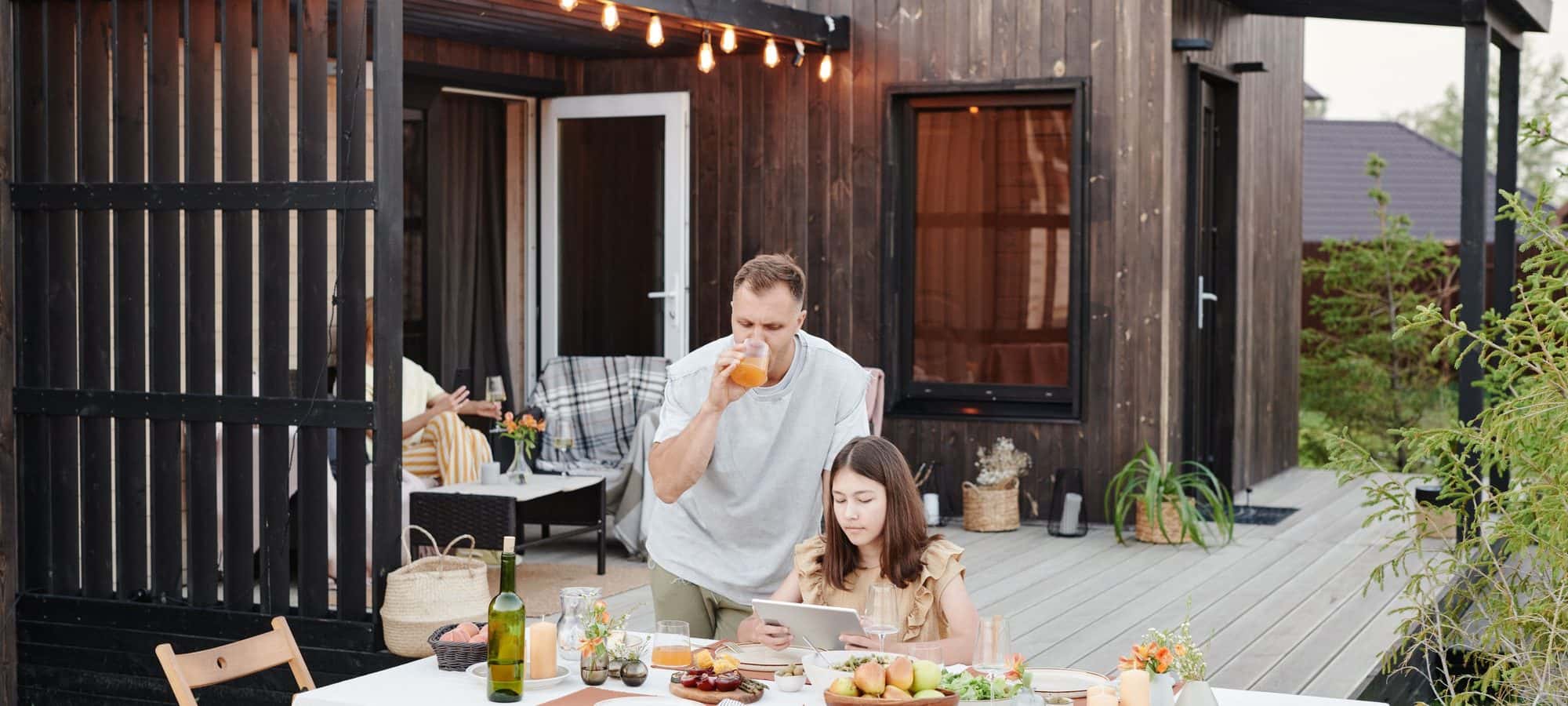 Couple having dinner on a lit outdoor deck in the evening