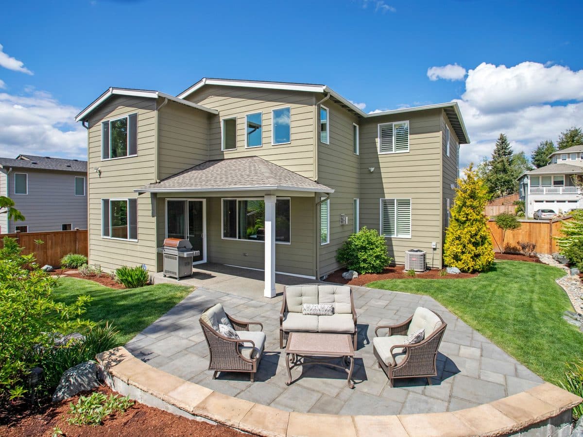Tidy suburban backyard with patio seating and a landscaped garden border