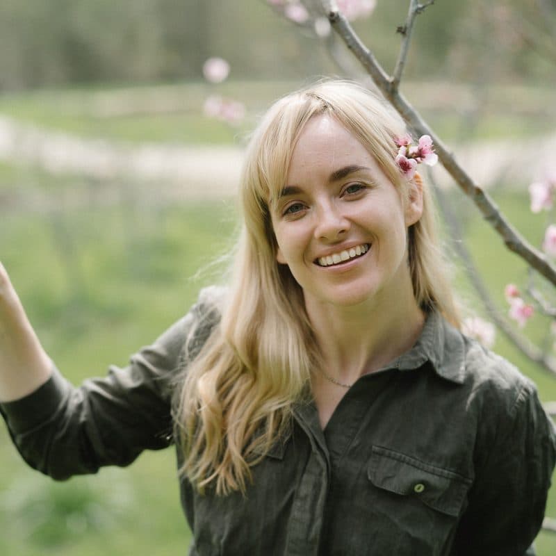 Hannah Reeves, landscape designer, holding pruners in a garden