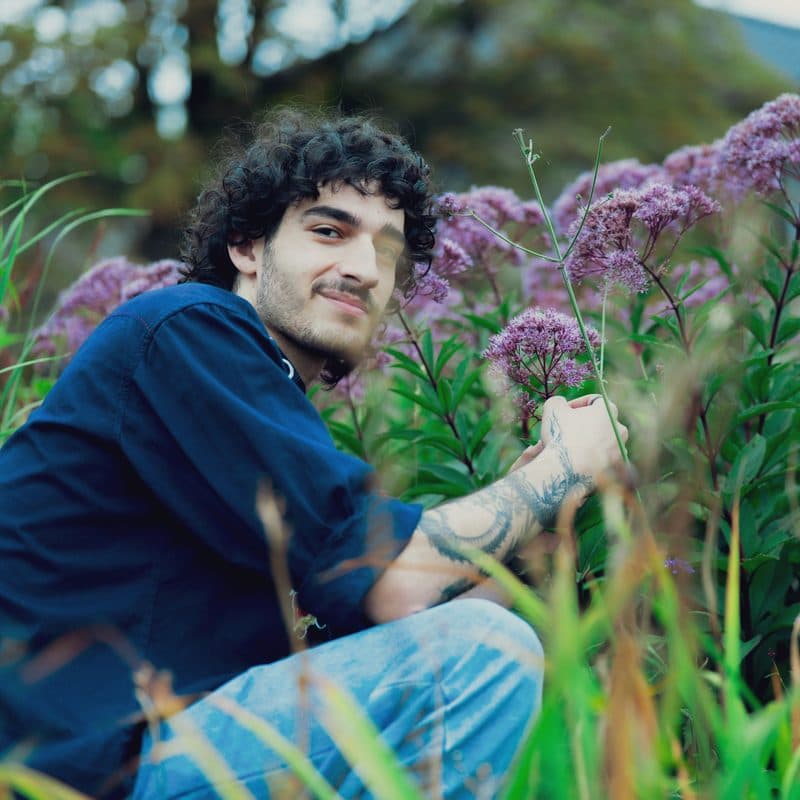 Diego Marín, installation foreman, working among flowering plants